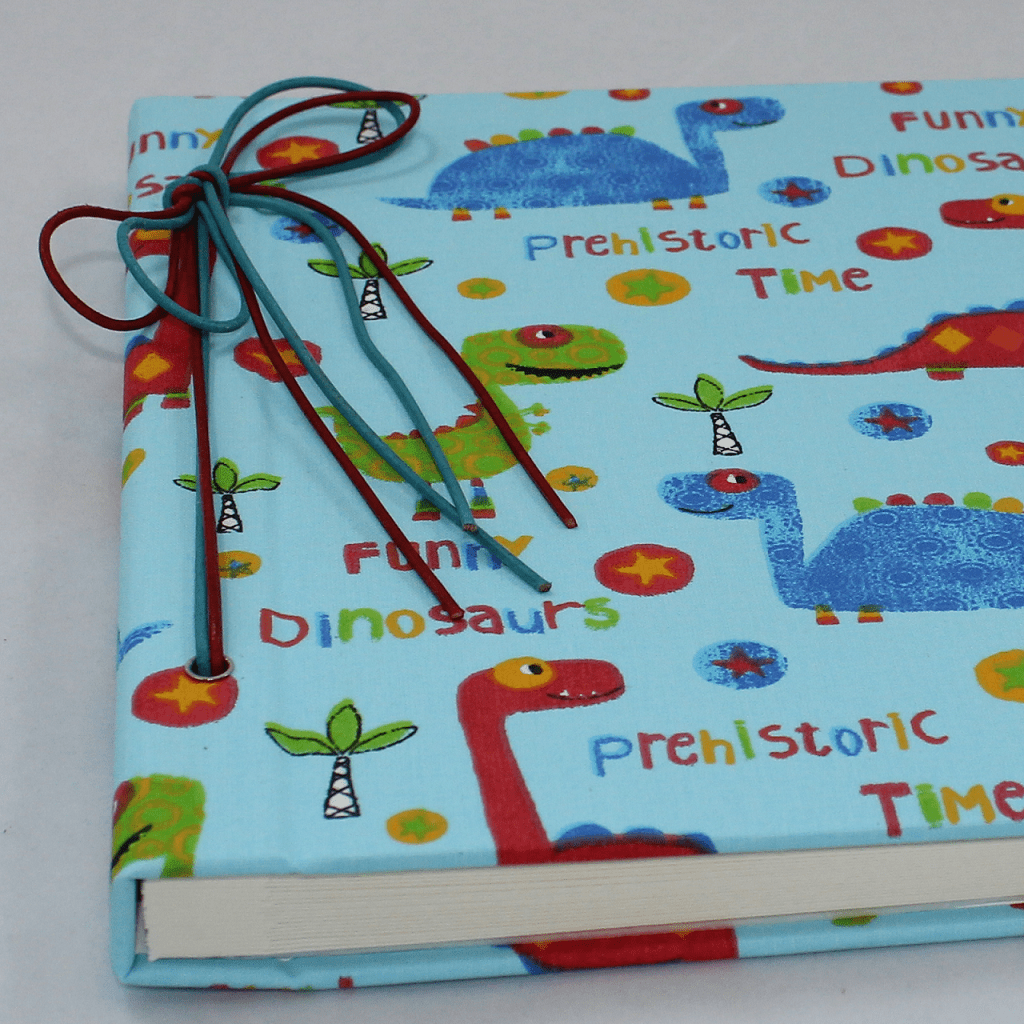 Baumwollstoff mit bunten Dinomotiven und Pergaminpapier Seidenwurm