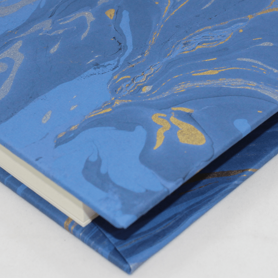 Notizbuch Marmoreffekt mit Stifthalter in blau mit von Hand eingeschlagenen Ecken